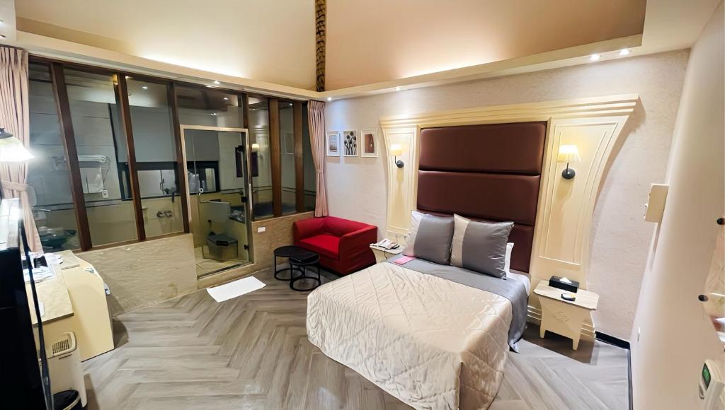 ein Hotelzimmer mit einem Bett und einem roten Stuhl in der Unterkunft Giyoche Motel in Wanli