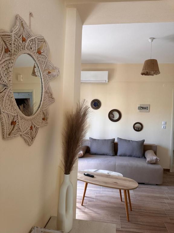 a living room with a couch and a mirror at Elinor Pefkochori in Pefkohori