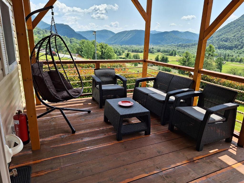 a porch with chairs and a swing and a table at MOBILE HOUSE KD in Tolmin