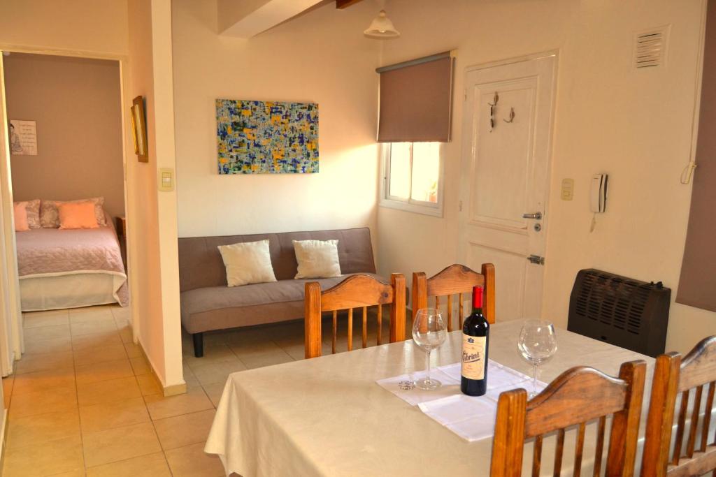 a dining room with a table with a bottle of wine at MendoApart completo con cochera in La Cieneguita