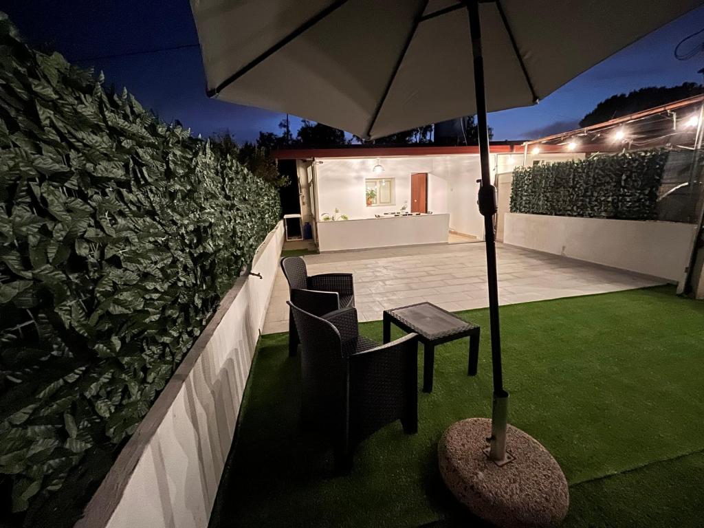a patio with a table and chairs and an umbrella at Maria Apartment in Vaccarizzo - Delfino