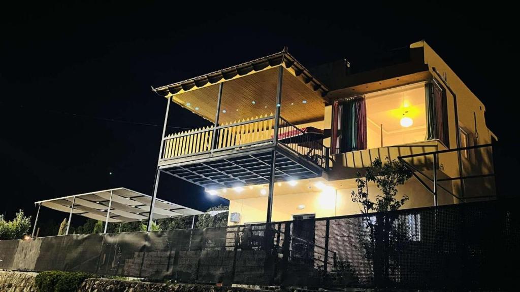 Una casa se ilumina por la noche con luces en Mustafa Farm, en Ajloun