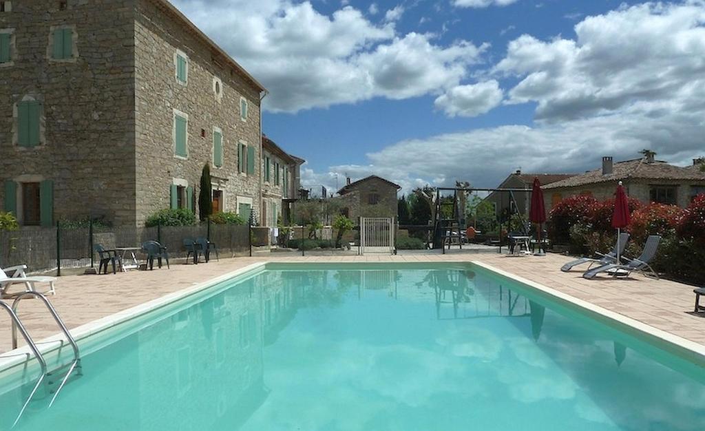 a large swimming pool in front of a building at La Bastide des Lavandieres - Apartment Cerise in Canaules-et-Argentières