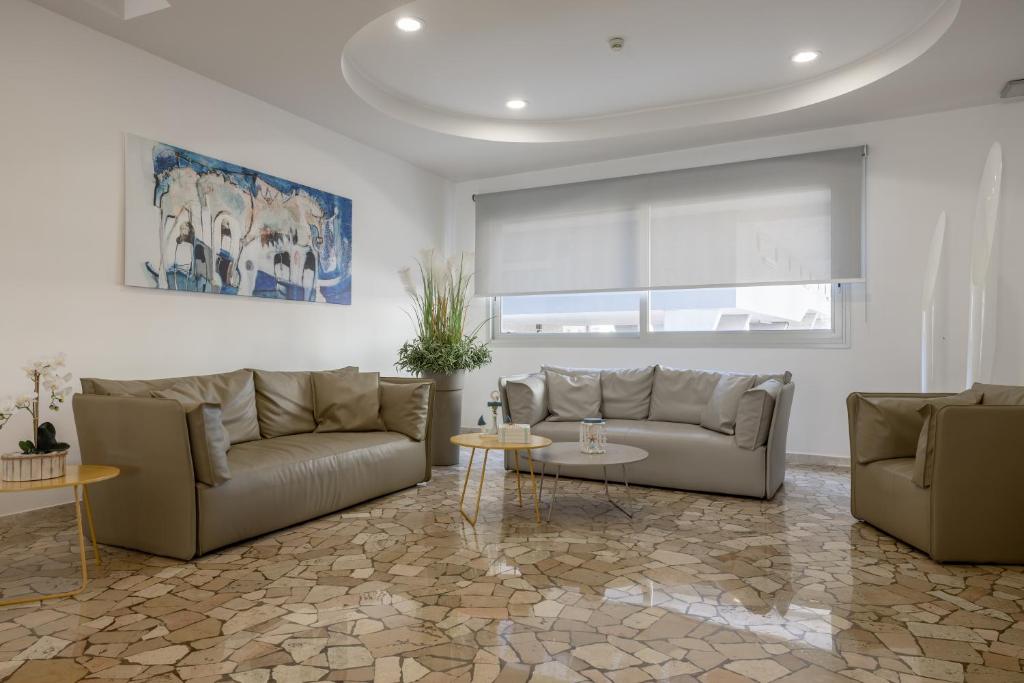 a living room with two couches and a table at Hotel Bristol in Caorle