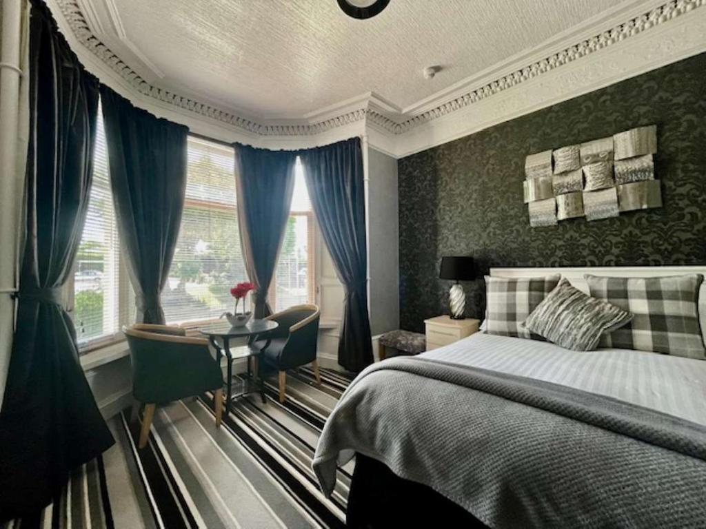 sypialnia z łóżkiem, stołem i oknem w obiekcie Vaila Guest House w Aberdeen