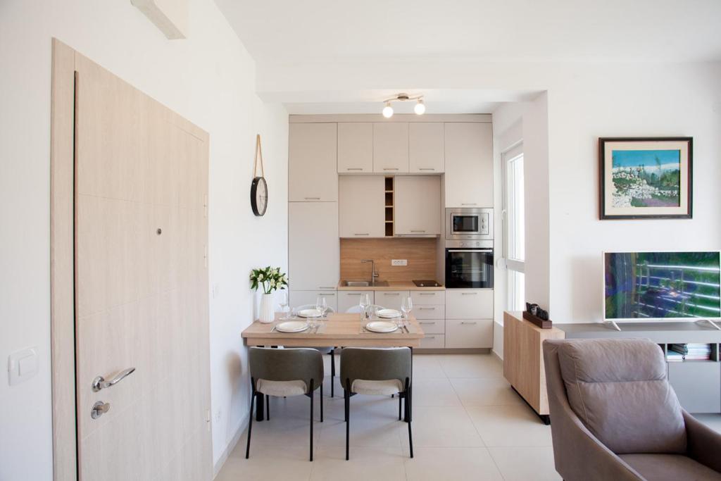 a kitchen and dining room with a table and chairs at Boka Panoramic in Đenovići