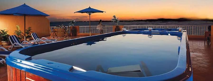 ein blauer Pool mit Sonnenuntergang im Hintergrund in der Unterkunft بورتو السخنه -Hotel Porto vib in Ain Suchna