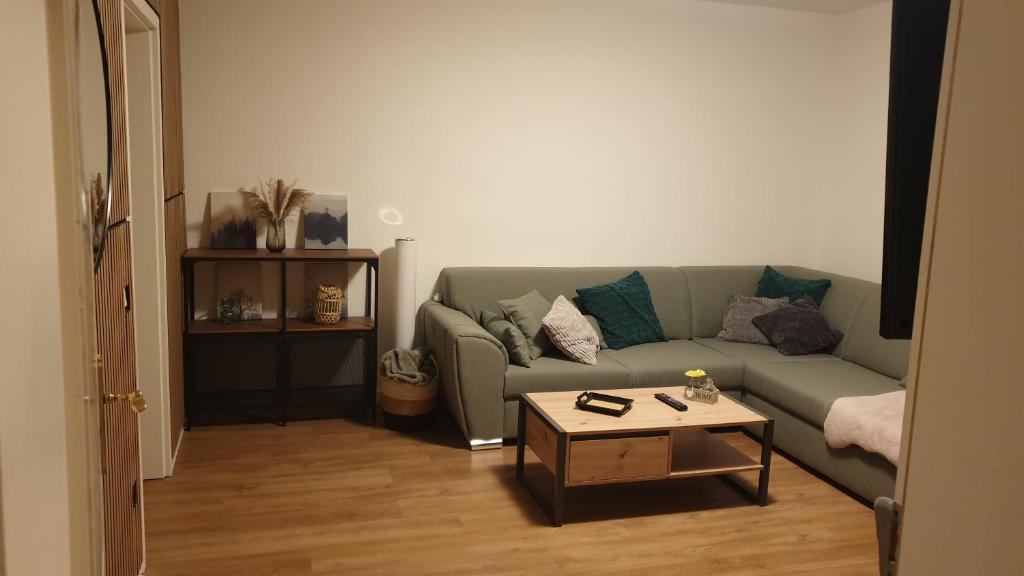 a living room with a green couch and a coffee table at 3-Zimmer mitten in Siegburg in Siegburg