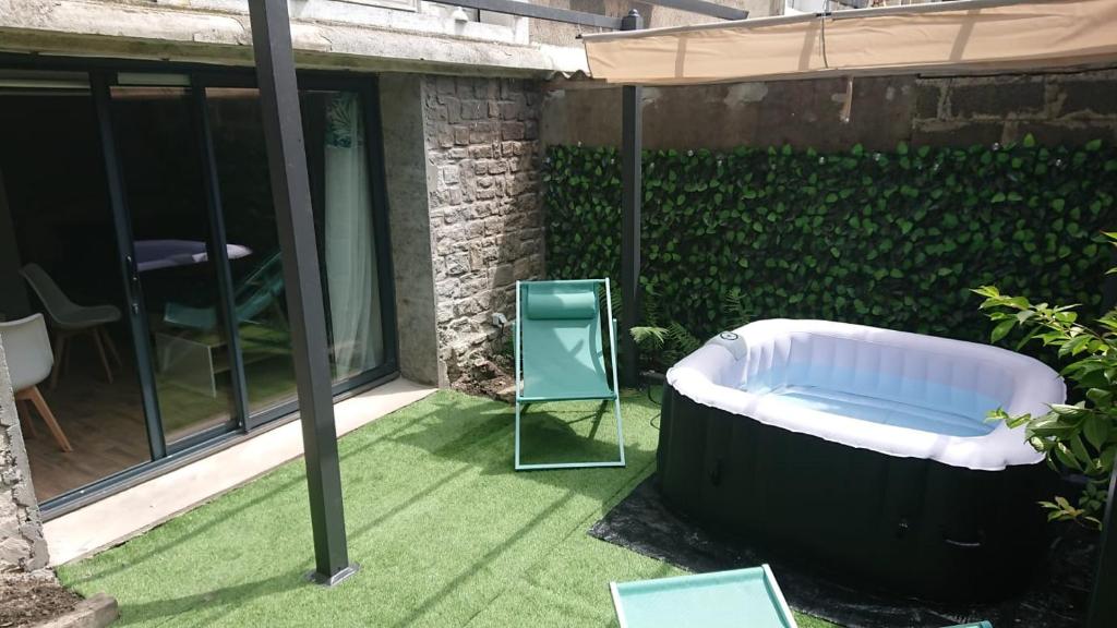 une baignoire assise dans un jardin avec une chaise dans l'établissement Cocon avec spa dans le centre, à Boulogne-sur-Mer