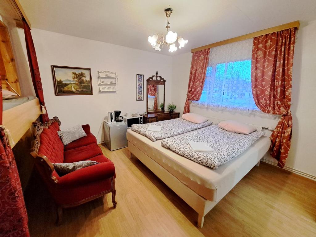 a bedroom with a bed and a red chair at Akureyri Center Rooms in Akureyri