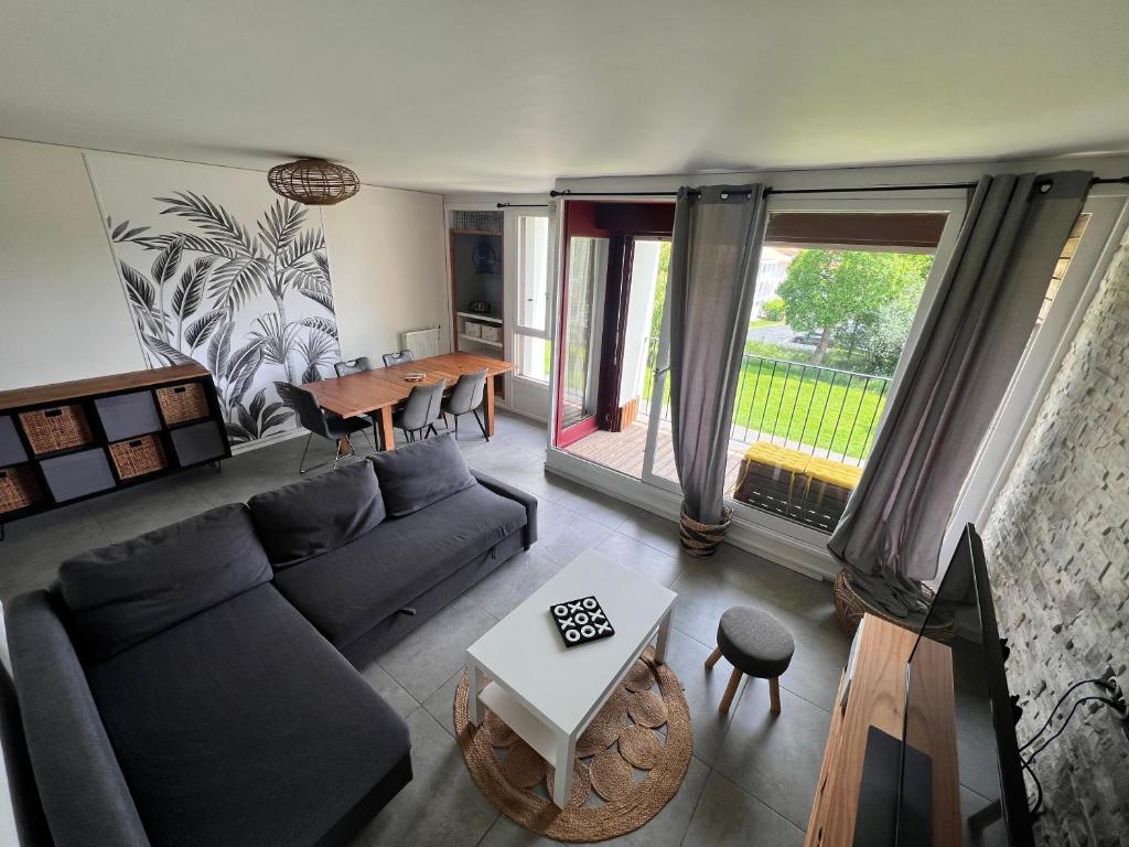 un salon avec un canapé et une table dans l'établissement Appartement grande capacité Bayonne, à Bayonne