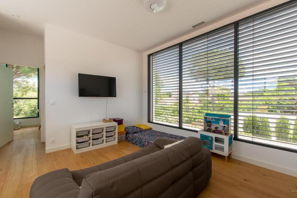 Televízia a/alebo spoločenská miestnosť v ubytovaní LA CONTEMPORAINE au calme avec sa piscine, wifi fibre, 8 personnes