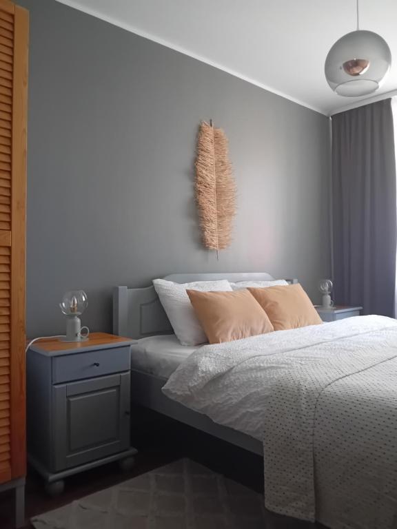 een slaapkamer met een bed en een nachtkastje ernaast bij Zvejnieku apartamenti in Roja