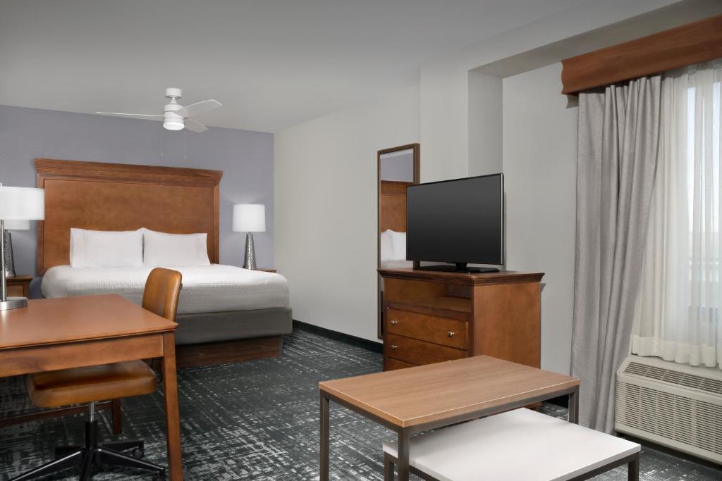 Pokój hotelowy z łóżkiem, biurkiem i telewizorem w obiekcie Homewood Suites by Hilton Omaha - Downtown w mieście Omaha