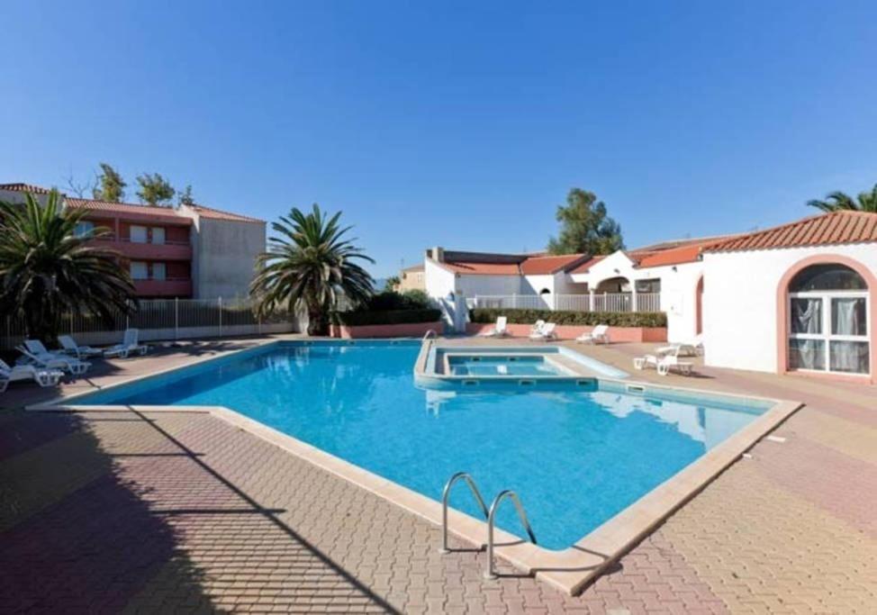 - une grande piscine dans une cour avec une maison dans l'établissement Joli T2 au coeur de la résidence Europa à Canet, à Canet