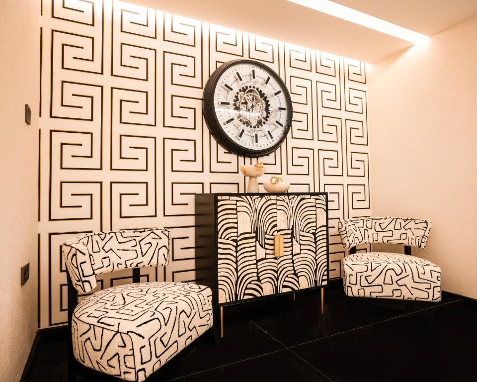 a room with two chairs and a clock on a wall at Sile Gonen Hotel in Şile