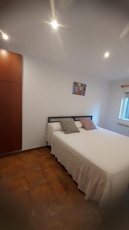two beds in a room with white walls at Casa cheve in Cangas de Morrazo