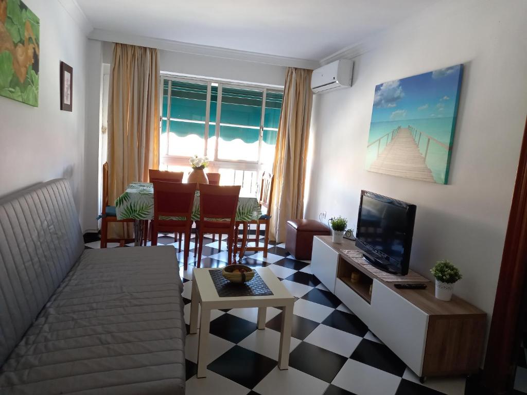 a living room with a couch and a tv at Malaga downtown and beach apartment in Málaga