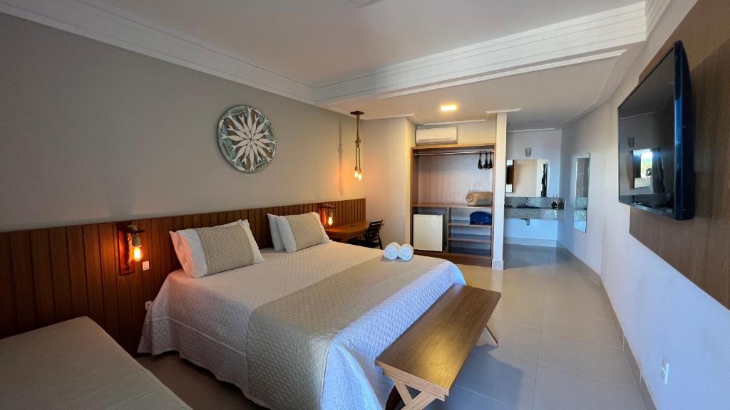 1 dormitorio con 1 cama grande y cocina en Pousada Timoneiro, en Vila Velha