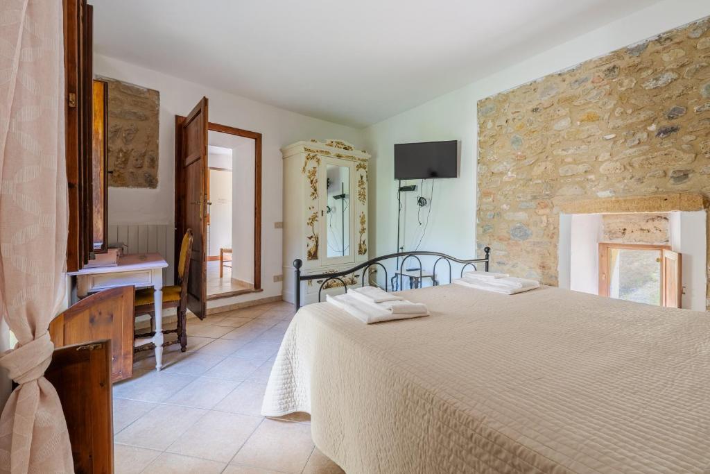 1 Schlafzimmer mit einem großen Bett und einem Badezimmer in der Unterkunft Molino del prato in Volterra