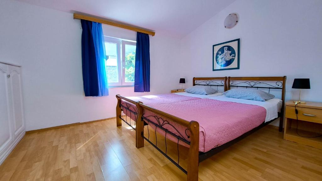 克雷克的住宿－Apartman Bebic，一间卧室配有一张带粉色毯子的大床