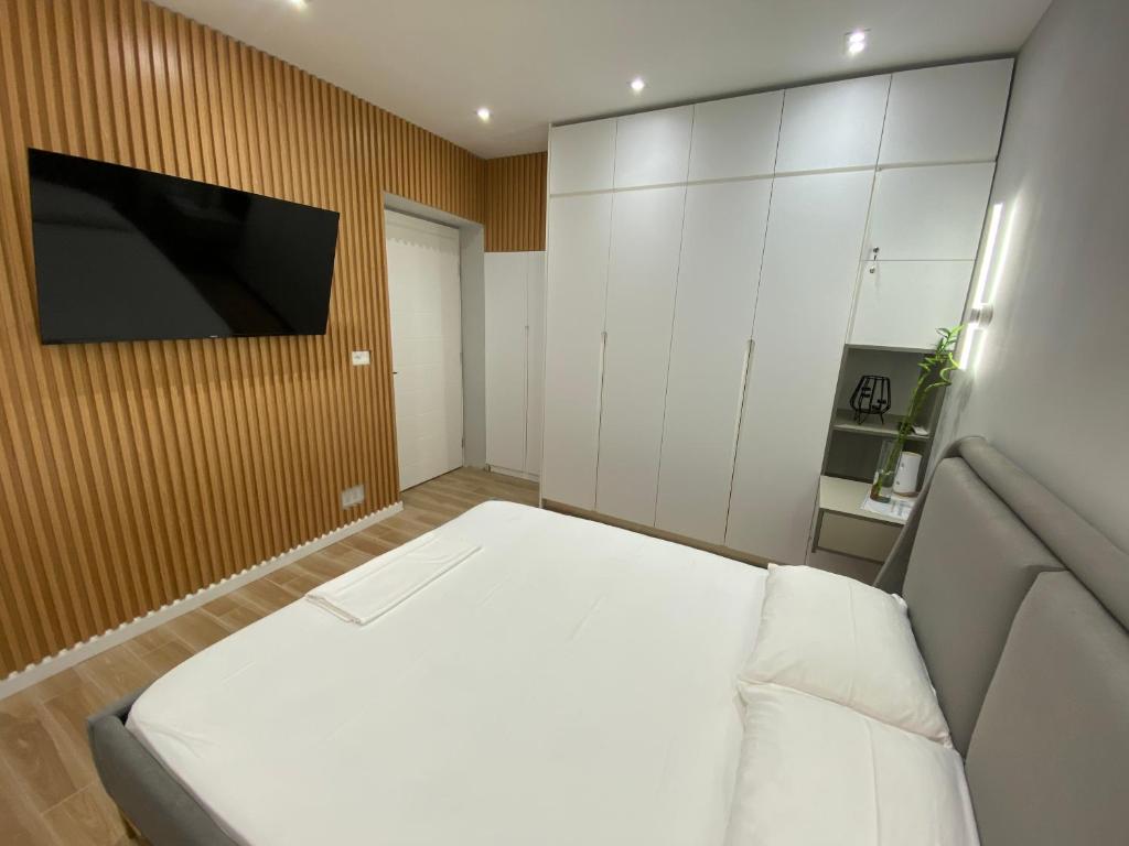Un dormitorio con una cama y un televisor en una pared. en Bliss Apartment - Luxury and Cosy, en Berat