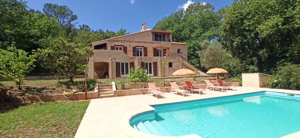 une maison avec une piscine devant une maison dans l'établissement Villa au cœur de la Provence, à Lorgues
