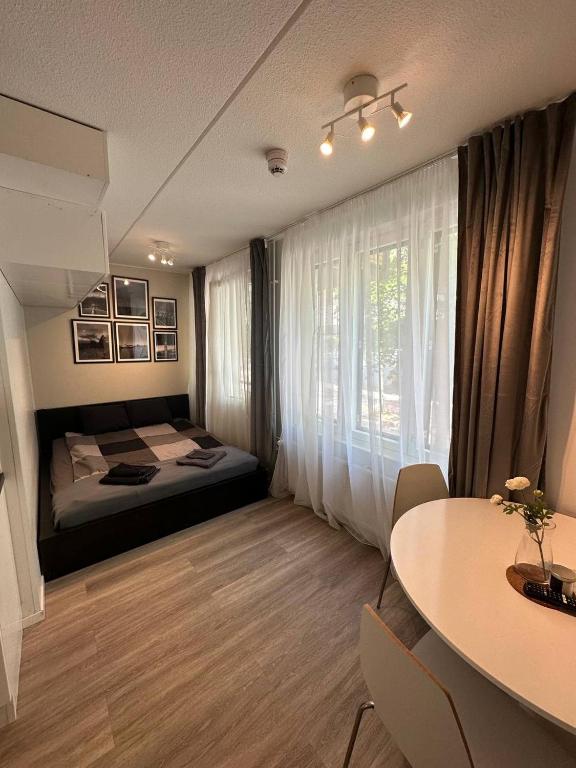 Schlafzimmer mit einem Bett, einem Tisch und einem Fenster in der Unterkunft Cozy studio apartment in Helsinki