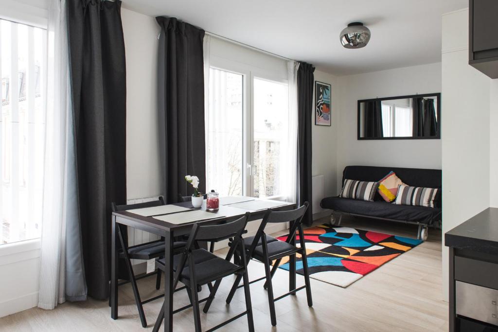 une salle à manger avec une table et des chaises dans une pièce dans l'établissement HomyParis, à Paris