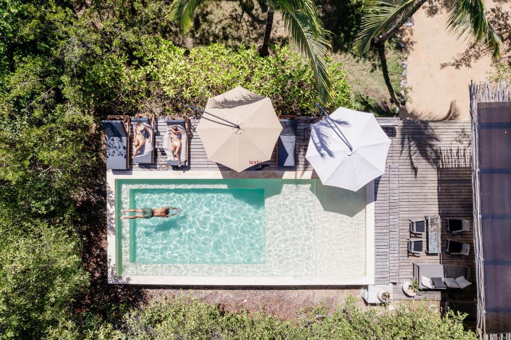 an overhead view of a swimming pool with umbrellas at Vida Silvestre in Tulum
