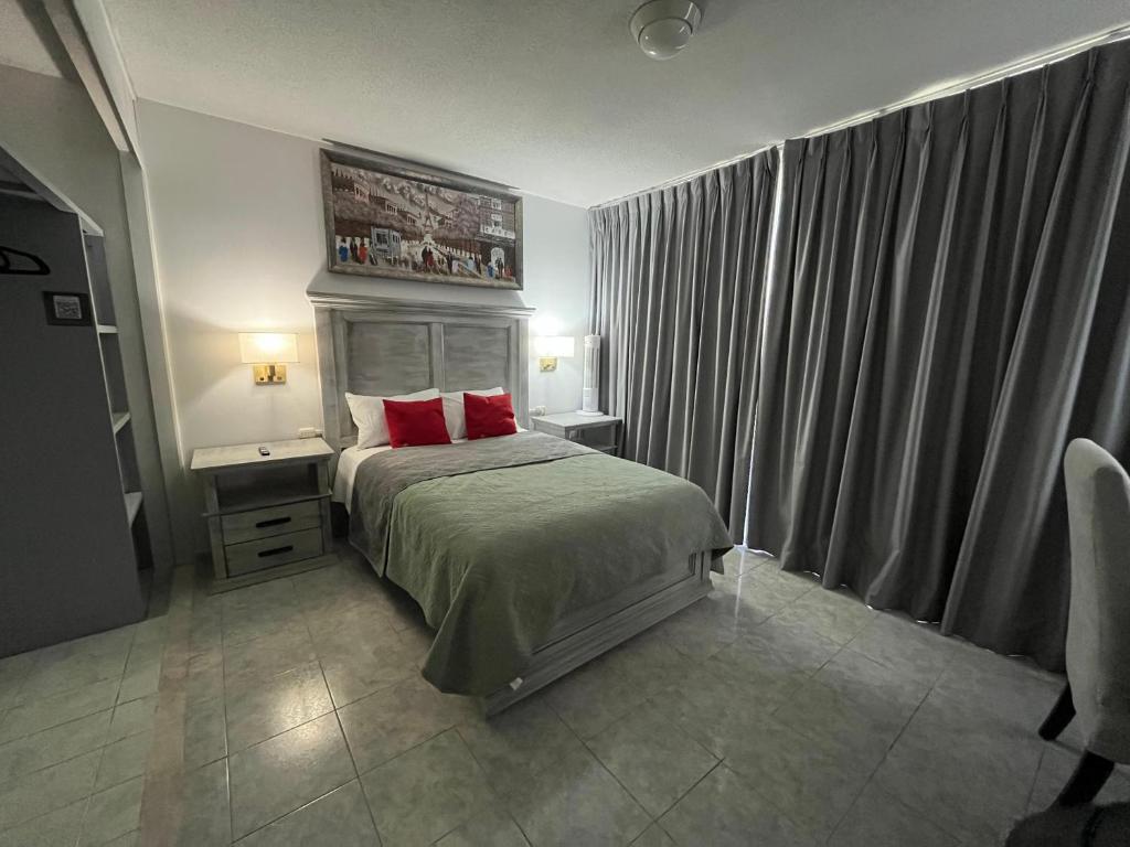 a bedroom with a bed with two red pillows at 5 VENATOR House Boutique in León