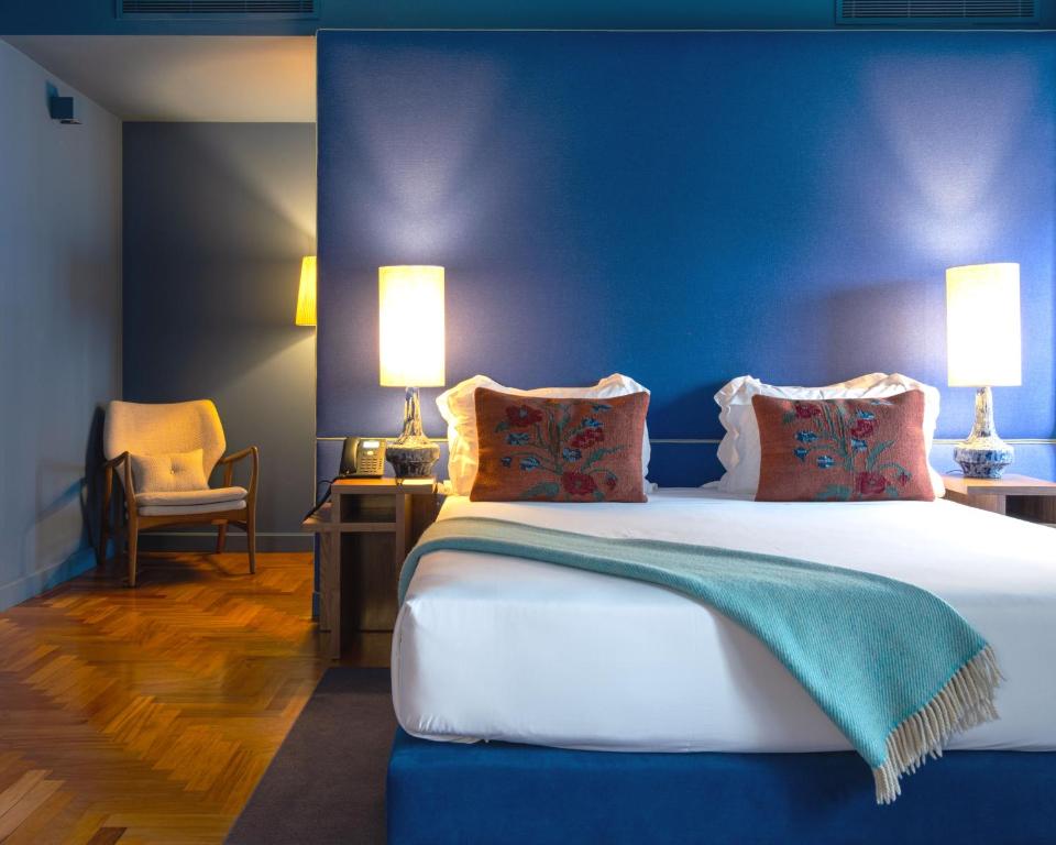 a bedroom with a large bed with a blue wall at Villa Cascais Boutique Hotel in Cascais