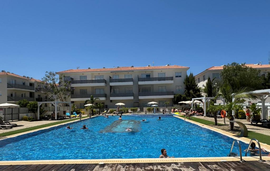 a large swimming pool in front of a building at Cosy apartment at Mythical Sands resort in Paralimni
