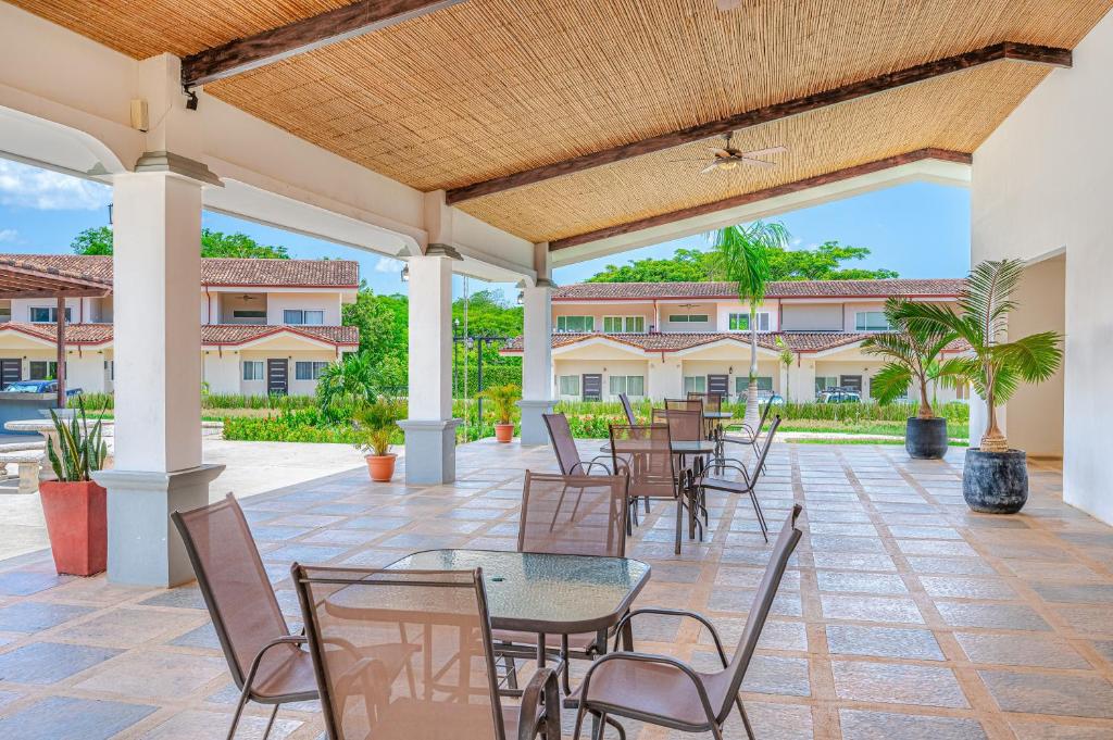 a patio with tables and chairs in front of a building at Jacarandas 4 in Tamarindo