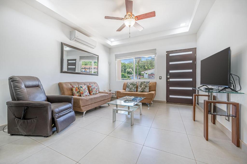 a living room with a couch and a tv at Jacarandas 4 in Tamarindo