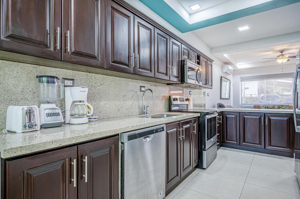 a kitchen with wooden cabinets and a counter top at Jacarandas 4 in Tamarindo