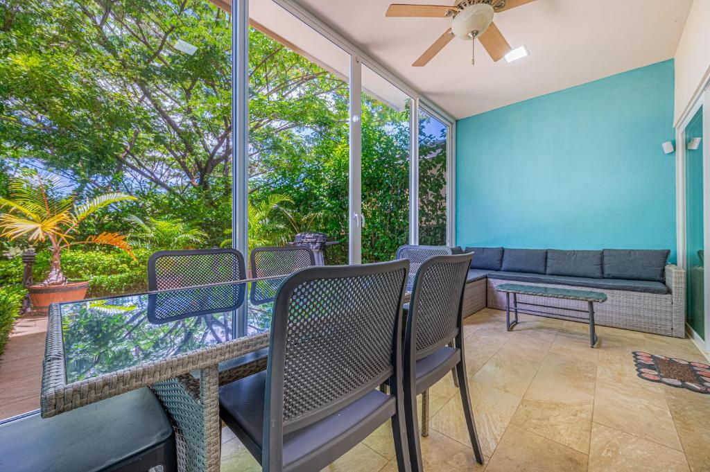 a screened in porch with chairs and a couch at Jacarandas 4 in Tamarindo
