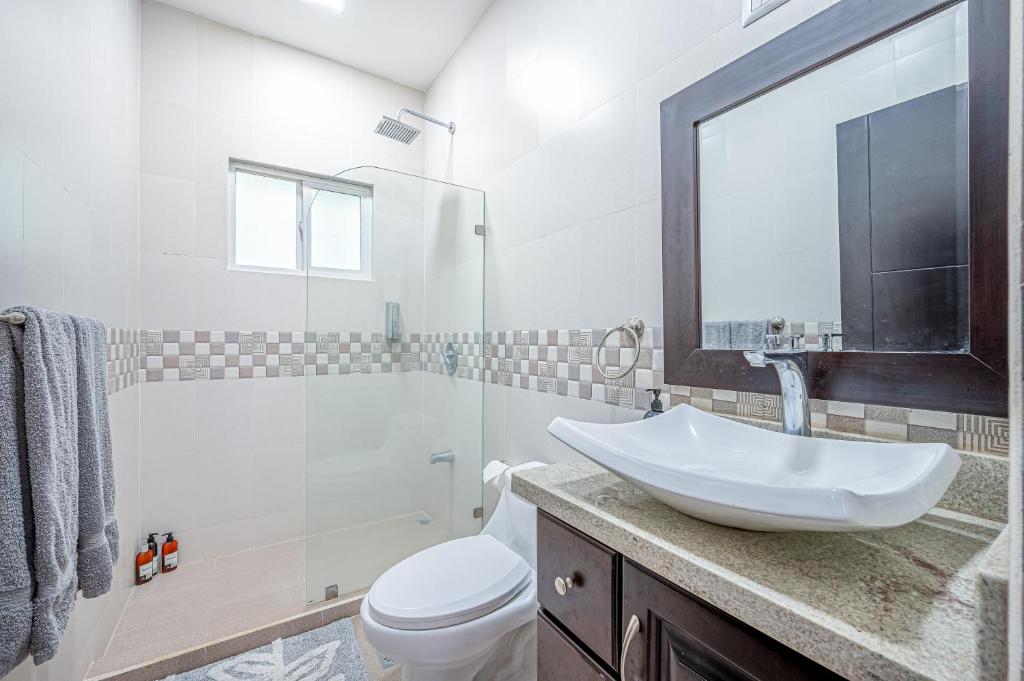 a bathroom with a sink and a toilet and a shower at Jacarandas 4 in Tamarindo