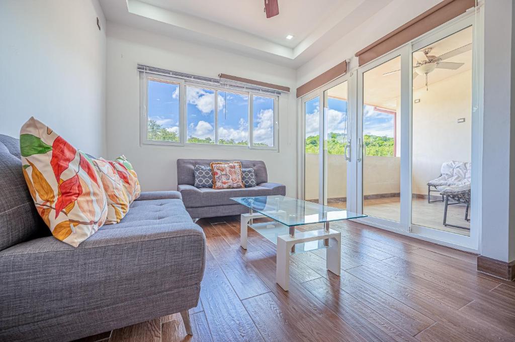 a living room with a couch and a glass table at Jacarandas 4 in Tamarindo