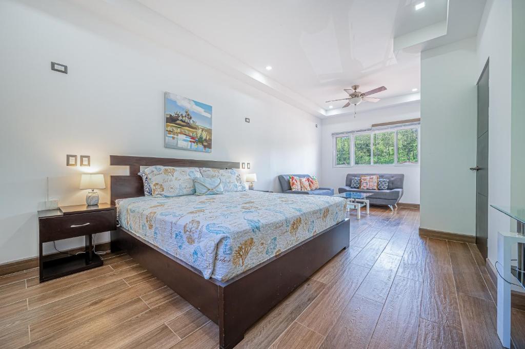 a bedroom with a bed and a desk and a chair at Jacarandas 4 in Tamarindo