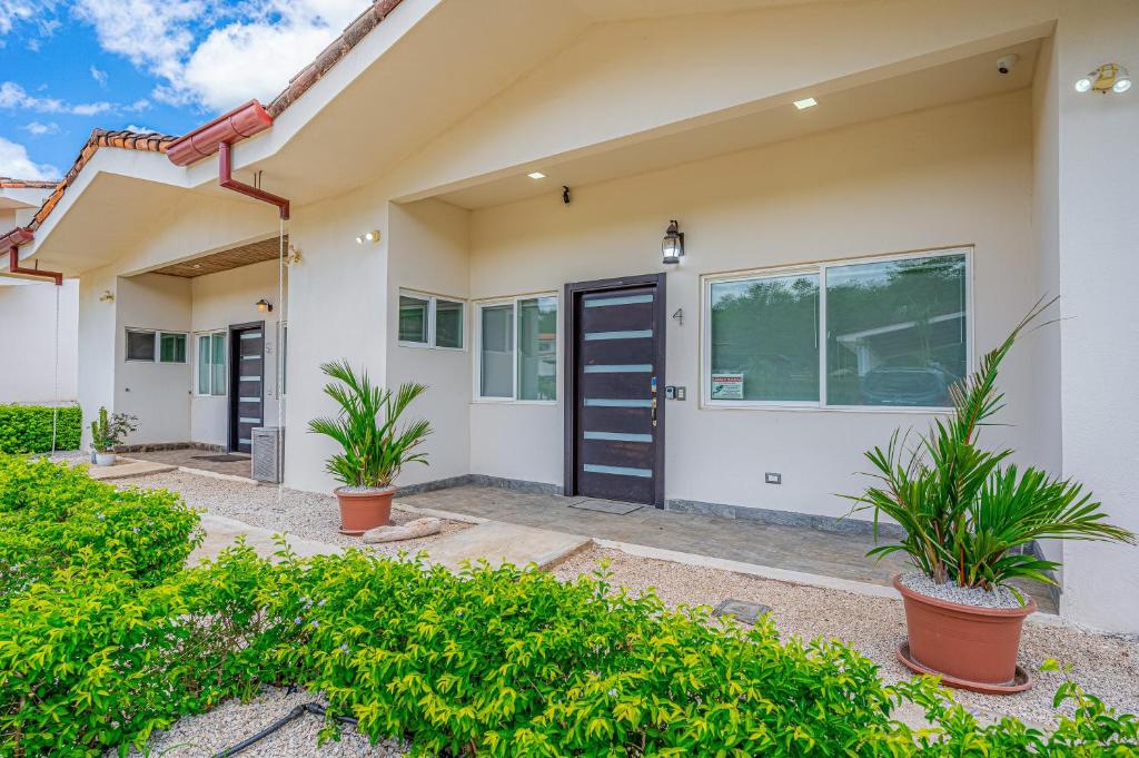 a house with a black door and plants at Jacarandas 4 in Tamarindo