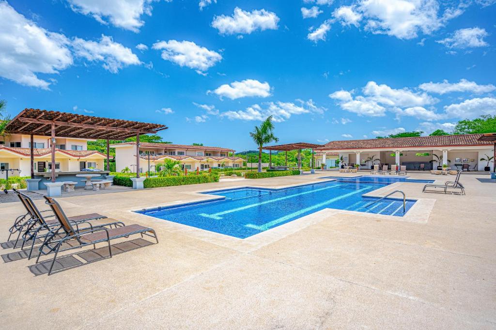 a swimming pool with lounge chairs and a resort at Jacarandas 4 in Tamarindo