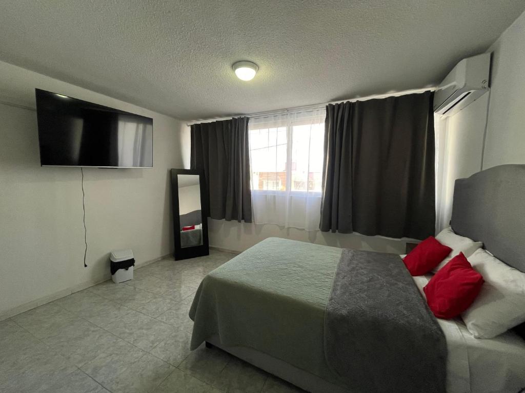 een hotelkamer met een bed en een flatscreen-tv bij 6 VENATOR House Boutique in León