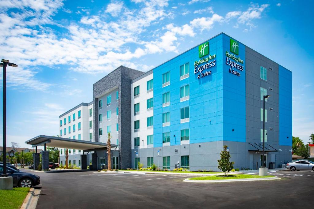 un edificio blu e bianco con parcheggio di Holiday Inn Express & Suites Pensacola Airport North – I-10, an IHG Hotel a Pensacola