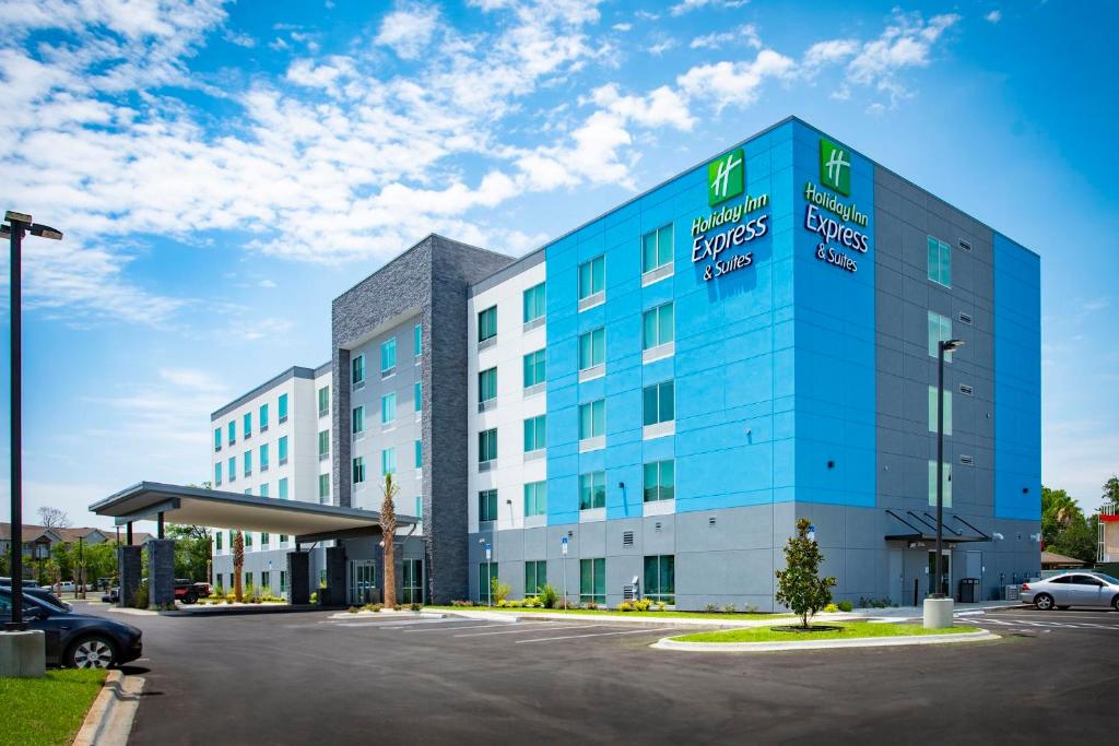 a blue and white building with a parking lot at Holiday Inn Express & Suites Pensacola Airport North – I-10 by IHG in Pensacola