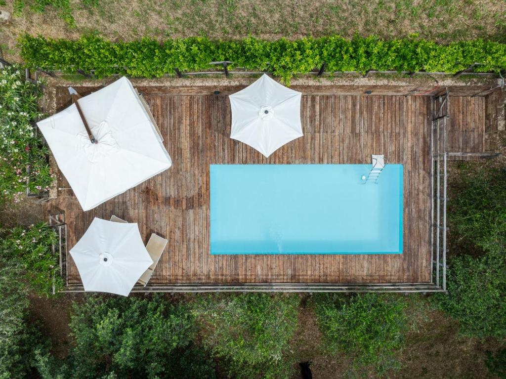 UzzanoにあるLa Casa sui Colliの傘3本とプールの上空の景色