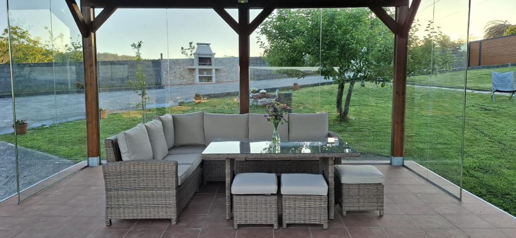 patio z kanapą, stołem i krzesłami w obiekcie Casa rural La casilla de Ois-Betanzos-A Coruña w mieście Coirós