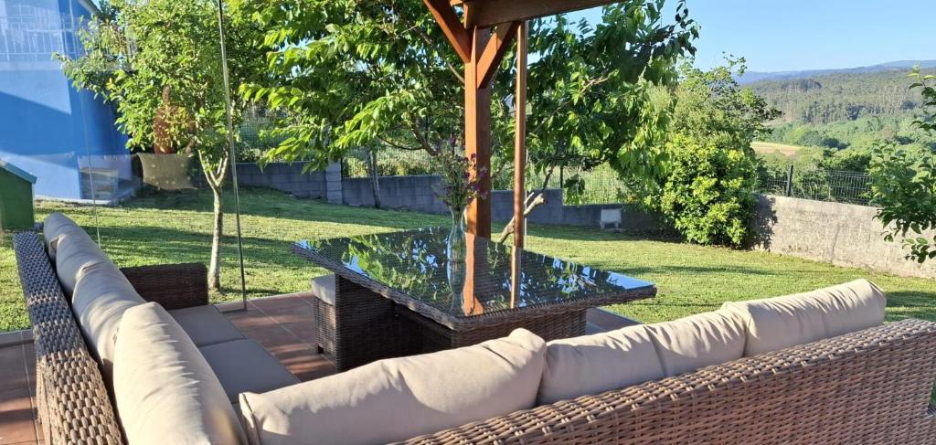 patio ze szklanym stołem i kanapą w obiekcie Casa rural La casilla de Ois-Betanzos-A Coruña w mieście Coirós