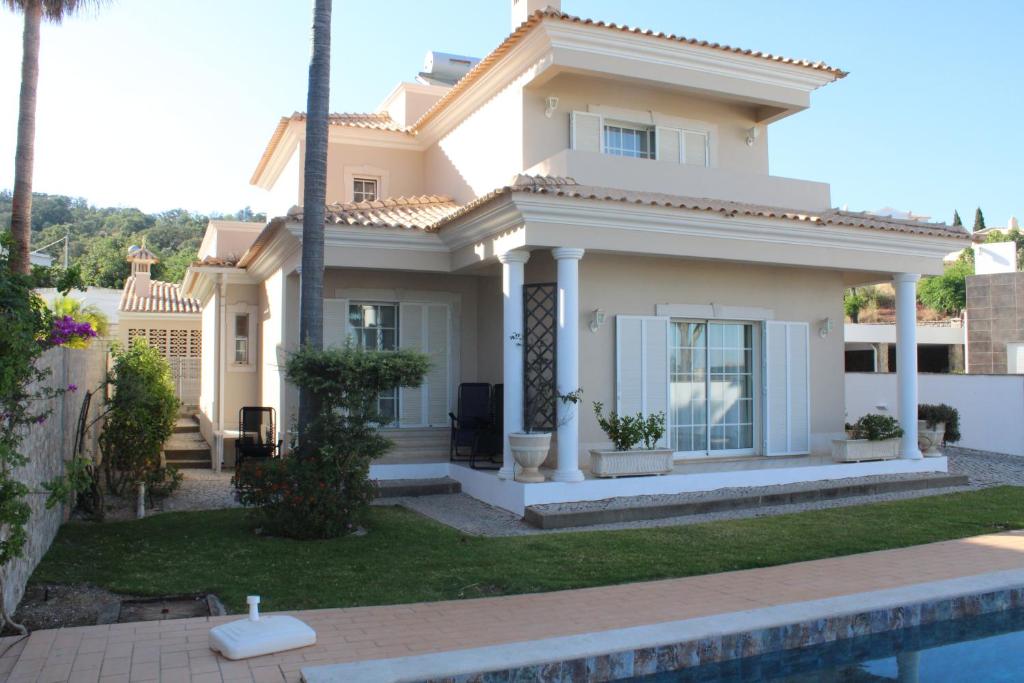 una casa blanca con una piscina delante de ella en CountrySide Villa, en São Brás de Alportel