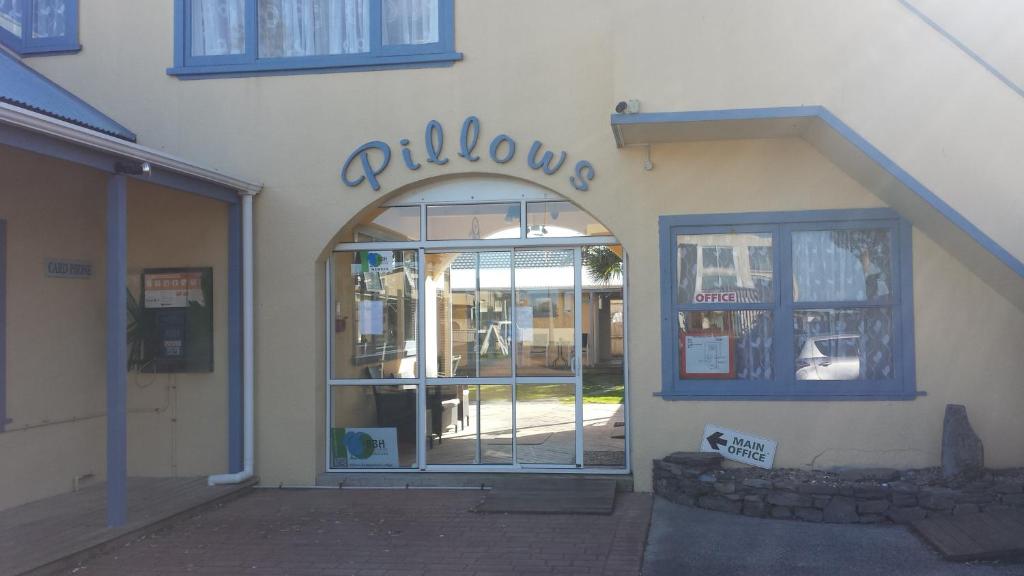 una entrada a una tienda con un letrero encima de la puerta en Orewa Pillows Lodge, en Orewa